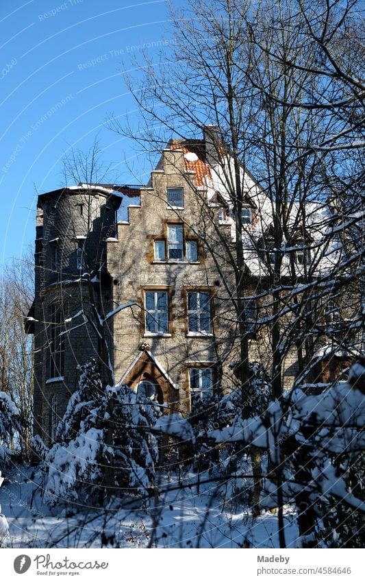 Die Alte Müllerburg mit Treppengiebel im Winter vor blauem Himmel im Sonnenschein in Oerlinghausen bei Bielefeld am Hermannsweg im Teutoburger Wald in Ostwestfalen-Lippe