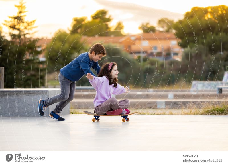 Zwei Freunde spielen mit einem Skateboard Holzplatte Junge Hermandad Brüder Kaukasier Kind Kindheit Großstadt kooperierende niedlich emotional Genuss Aufregung