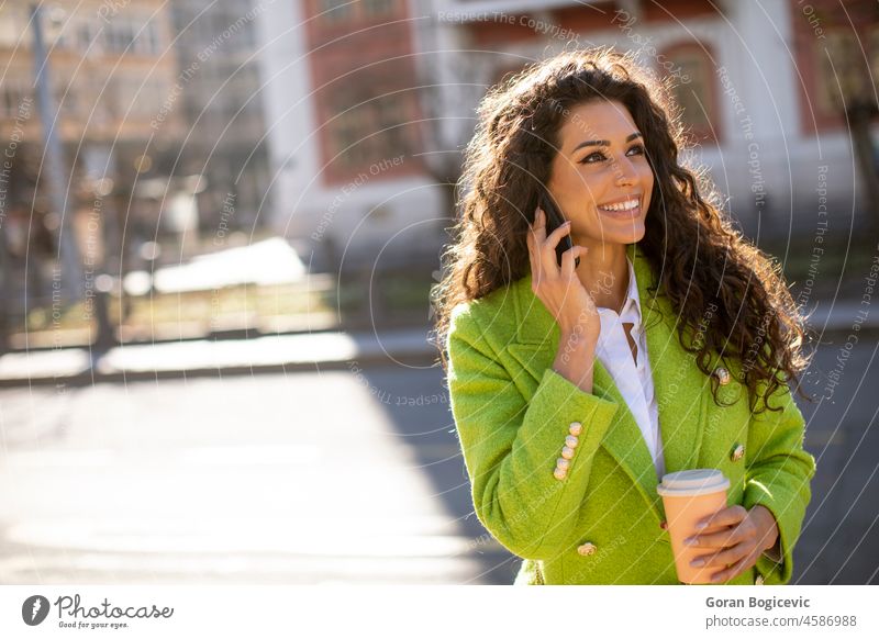 Junge Frau mit Smartphone auf der Straße und Kaffee zum Mitnehmen in der Hand schöne Menschen schöne Frau lässig Funktelefon heiter Großstadt Stadtleben