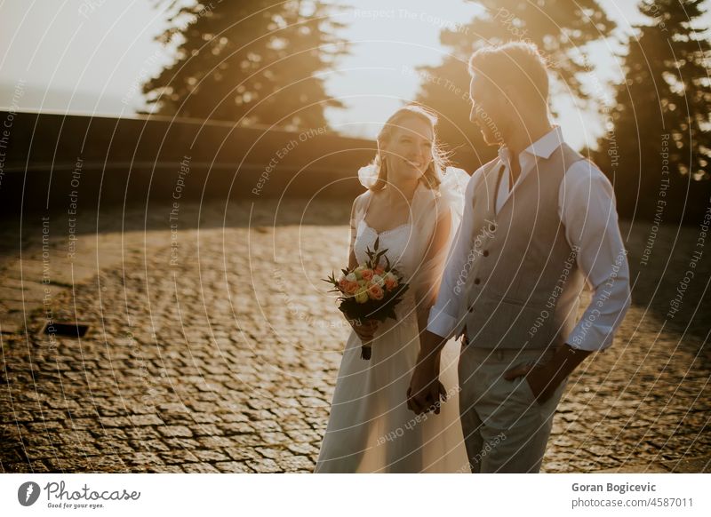 Junges, frisch verheiratetes Paar beim Spaziergang im Park schön Schönheit Braut Kaukasier heiter Kontakt Tag Kleid Umarmen Emotion Familie Gefühle Frau Ingwer