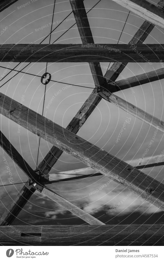 Alter Holzminenschacht Nutzholz hölzern Bergbau Schacht alt Industrie Menschenleer Schwarzweißfoto Himmel verfallen Industriekultur Bauwerk Rack Fachwerkträger