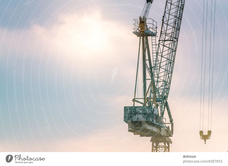 Baukran gegen blauen und rosa Himmel. Immobilien-Industrie. Baukran Verwendung Haspel heben Ausrüstung auf der Baustelle. Kran zu mieten. Crane Händler für Bauunternehmen.