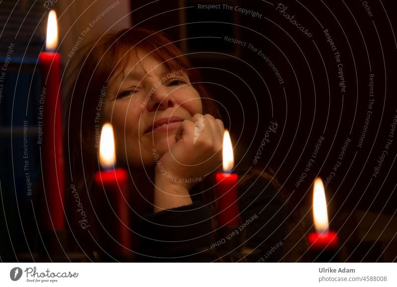 Frohe Weihnachten - Porträt einer Frau, mit vier Kerzen im Vordergrund sympathisch Fröhlichkeit offen herzlich Blick nach vorn Ungeschminkt natürlich Glück