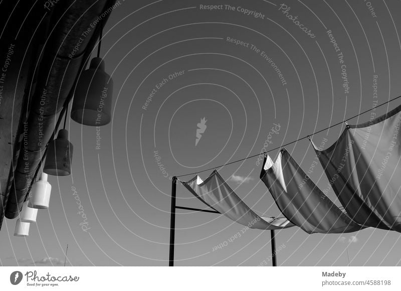 Deckenlampen und Sonnensegel im Sommer bei Sonnenschein auf der Dachterrasse eines Hotel in der Altstadt von Taksim an der Istiklal Caddesi im Stadtteil Beyoglu am Bosporus in der Türkei