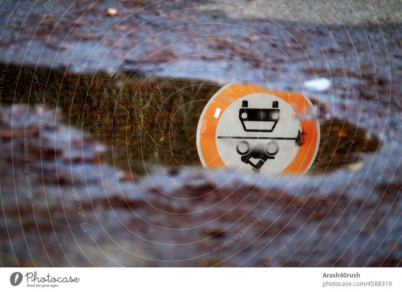 Verkehrsschild / Spiegelung in einer Pfütze Spiegelbild straßenschild verkehrsschild ,Straße nass Außenaufnahme dunkel Regen rund verrotten weiss schwarz