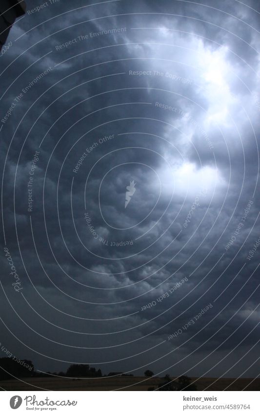 Dramatischer Himmel über freistehendem Haus dramatisch Hof Wetter Nachthimmel Licht düster duster Menschenleer Wolken Natur Außenaufnahme schlechtes Wetter