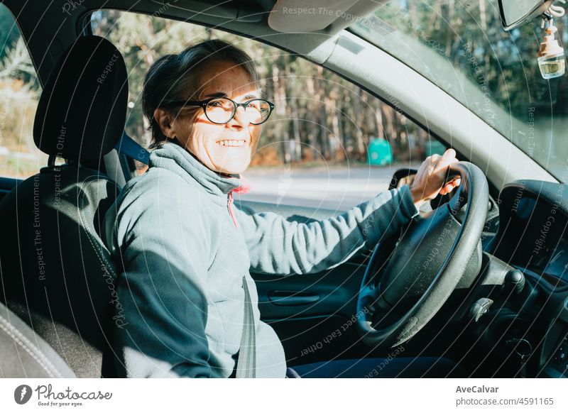 Porträt einer glücklich lächelnden älteren Frau, die das Autofahren lernt. Sicherheitsfahrt. Lernen neues Hobby, Gewohnheit und Fähigkeit für dieses neue Jahr. Ältere Person, die den Führerschein genehmigt.