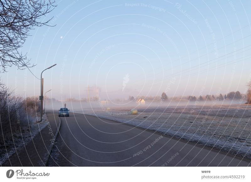 Ein Haus am Waldrand an einem nebligen Wintermorgen auf einer vereisten Wiese Augsburg Deutschland Raureif bedeckt Siebenbrunn kalt Textfreiraum Nebel Frost