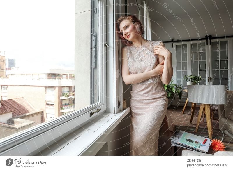 Junge Frau im Kleid schaut aus dem Fenster Stehen Person Kaukasier Dame Mädchen Lehnen Wegsehen stylisch Model melancholisch deprimierend besinnlich traurig