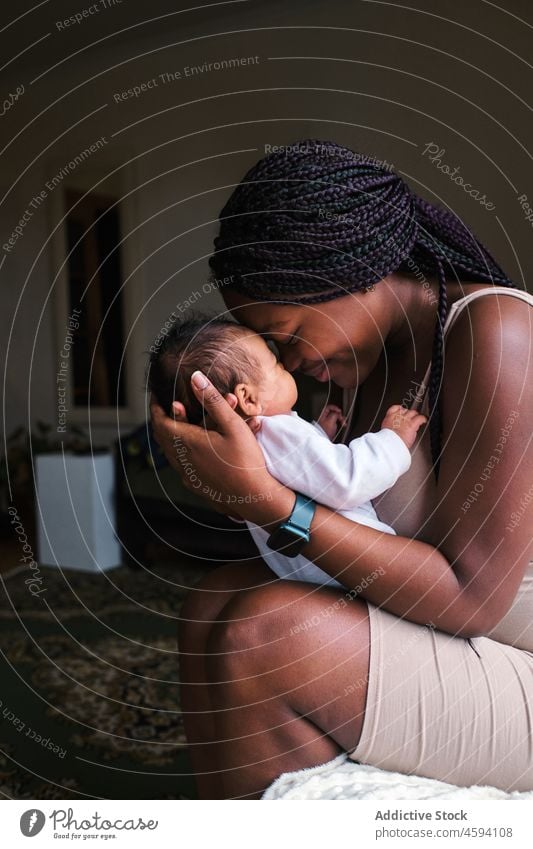 Schwarze sanfte Mutter streichelt süßes Baby Liebe Säugling Streicheln Umarmen Säuglingsalter Angebot Glück Frau kuscheln Zuneigung Mama Bonden Kind wenig