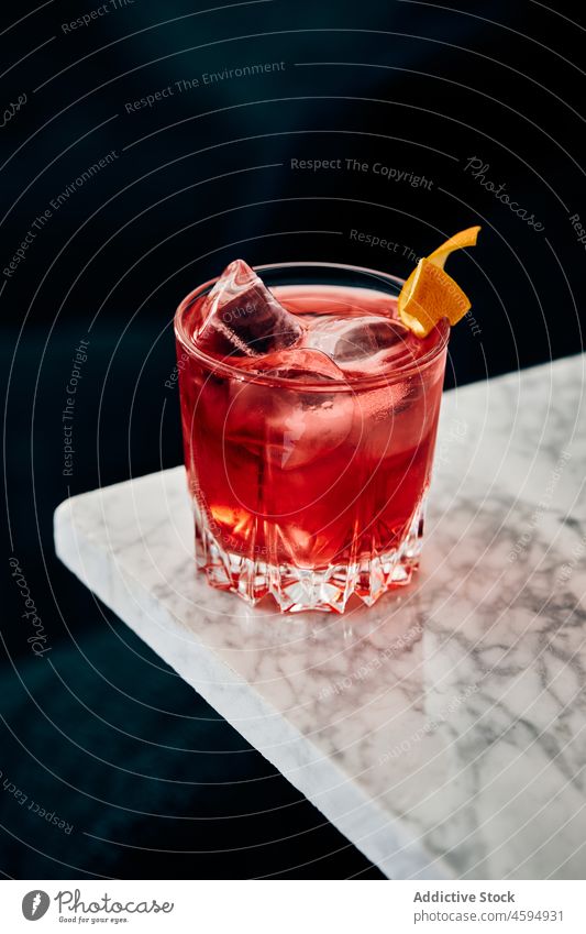 Glas eines klassischen Negroni-Cocktails auf einem Marmortisch negroni Alkohol Erfrischung trinken Getränk Sofa bitter Mischung Gin Wermut Eis mischen orange