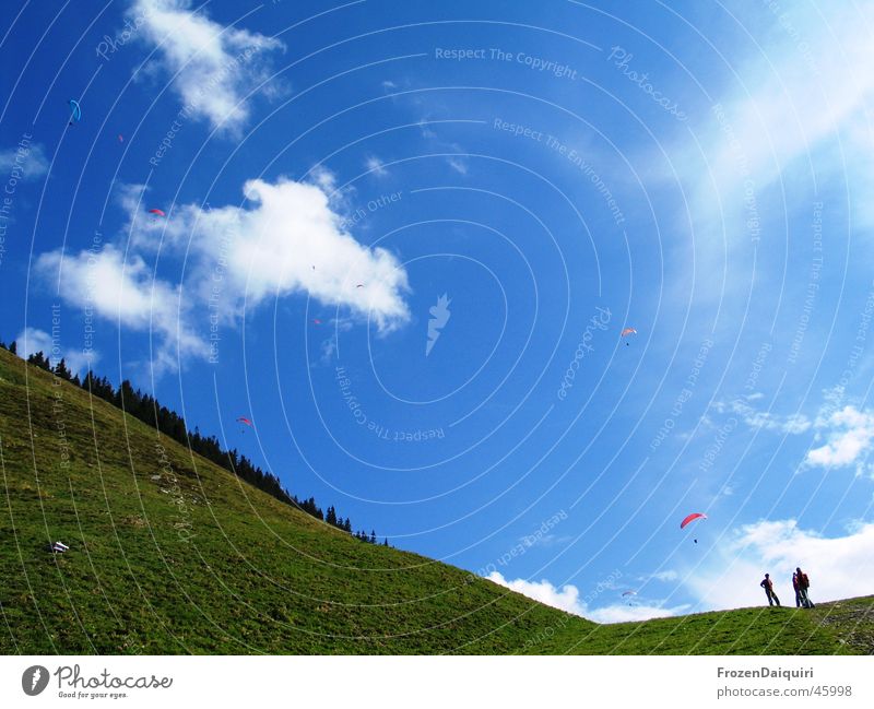 Ganz leiser Flugverkehr Wolken mehrfarbig Gleitschirm Luft weiß Berghang Schweben wandern Westendorf Bundesland Tirol Himmel paragleiter blau Erde