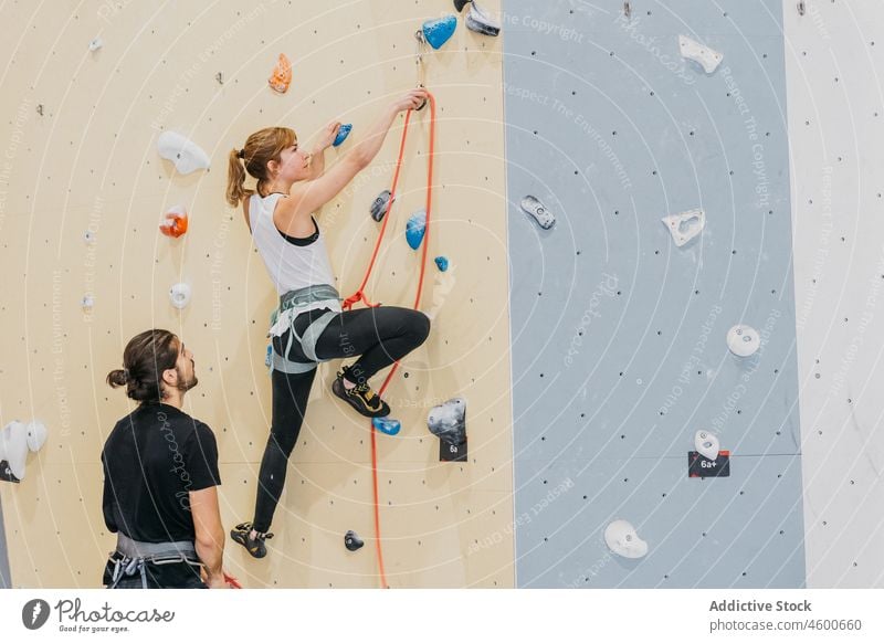 Pärchen übt Klettern an der Wand Sportler Aufstieg Training Kletterwand Alpinismus Übung üben abstützen Hilfsbereitschaft Seil sichern Alpinist