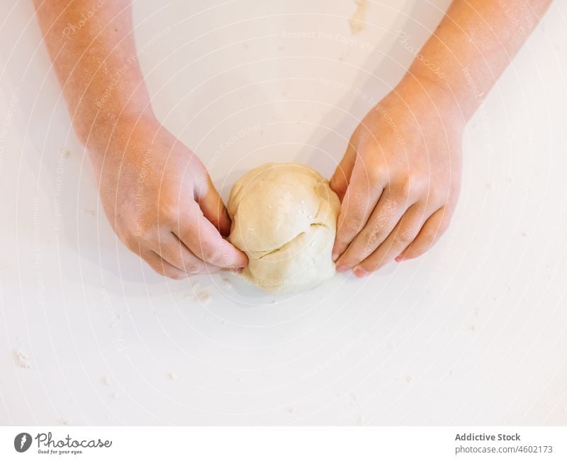 Anonymer Junge knetet Teig in der Küche Koch Kind Mehl kneten Gebäck Helfer Träne Schürze Prozess backen Lebensmittel heimisch Küchengeräte kulinarisch Produkt