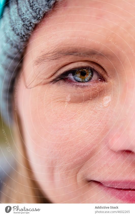 Frau in Mütze und Schal mit Träne in gefrorenem Tag Winter warm Fausthandschuh Oberbekleidung traurig weinen Frost rein warme Kleidung Wolle Strickwaren frieren