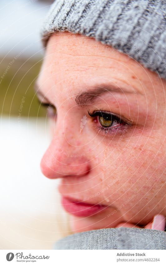 Frau in Mütze und Schal mit Träne in gefrorenem Tag Winter warm Fausthandschuh Oberbekleidung traurig weinen Frost rein warme Kleidung Wolle Strickwaren frieren