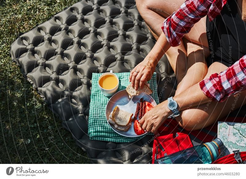 Frau frühstückt beim Zelt auf dem Campingplatz. Weibliche aktiv verbringen Sommerferien in der Nähe der Natur im Freien Urlaub Ausflug Abenteuer Frühstück