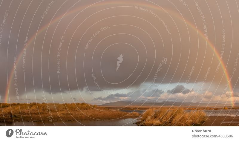 UK Wetter, Sandscale, Roanhead Cumbrian Coast. Regenbogen über dem schneebedeckten Black Combe über der Duddon-Mündung. Großbritannien Schnee kalt