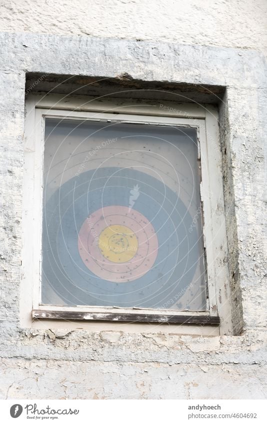 Ein durchlöchertes Ziel hinter einem alten Fenster genau Vorteil zielen Appartement Bogensport Holzplatte Volltreffer Zentrum Herausforderung kreisen Konkurrenz