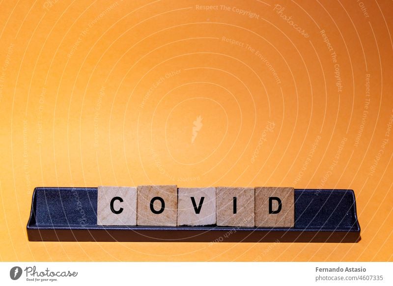 Coronavirus. Covid-19 mit Buchstaben geschrieben. Oranger Hintergrund und Platz für Text. Horizontale Fotografie. Krankheit Virus Seuche Pandemie medizinisch