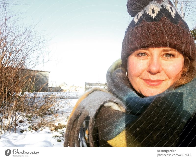 Voll Heiterkeit und Sonnenschein in  den Winter hinein Sonnenlicht Spaziergang kalt frostig Schnee Pudelmütze Schal weiß Natur Lächeln Klima Kleidung Wetter