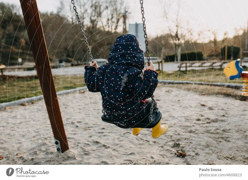 Rückansicht eines spielenden Kindes auf einem Spielplatz Kindheit Mädchen 3-8 Jahre eine Person Spielen Spielplatzgeräte pendeln Leben Kinderspiel Kindergarten