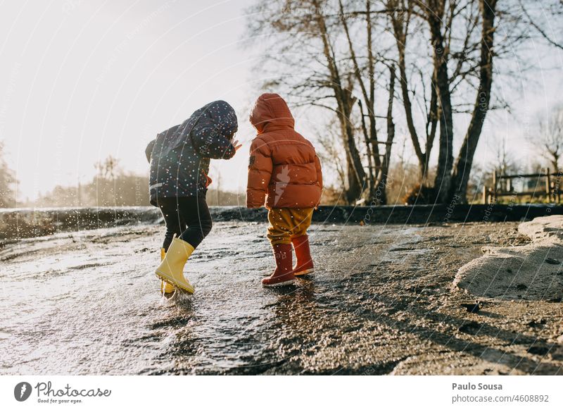 Bruder und Schwester spielen mit Wasser Geschwister Familie & Verwandtschaft Kind Kindheit 1-3 Jahre 3-8 Jahre Zwei Personen authentisch Winter Gummi