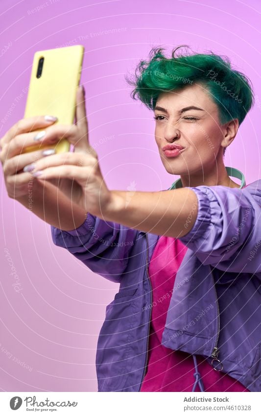 Fröhliche Millennial-Frau macht Selfie Smartphone Selbstportrait soziale Netzwerke Kopfhörer meloman Stil tausendjährig 80s Mode Design retro Atelier