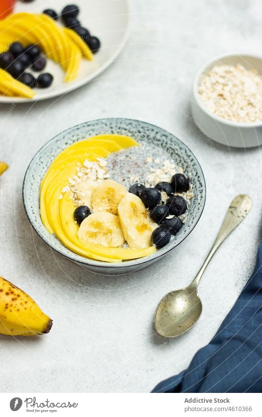 Gesundes Frühstück aus Müsli, Chia, Früchten und Beeren Morgen Banane Mango Blaubeeren Diät Supernahrung gesunde Ernährung frisch lecker Schalen & Schüsseln