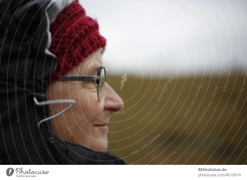 Seniorin im Profil mit Mütze Frau Großmutter Weiblicher Senior Erwachsene Oberkörper Brille beobachten natürlich Natur Umwelt Schwache Tiefenschärfe