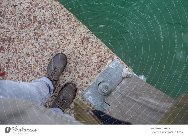 Am Rand grau locker sportlich kaltes Wetter von oben nach unten Holz Holzboden Wasser Brücke spazieren spazierengehen casual jeans Schnürschuhe Schnürstiefel