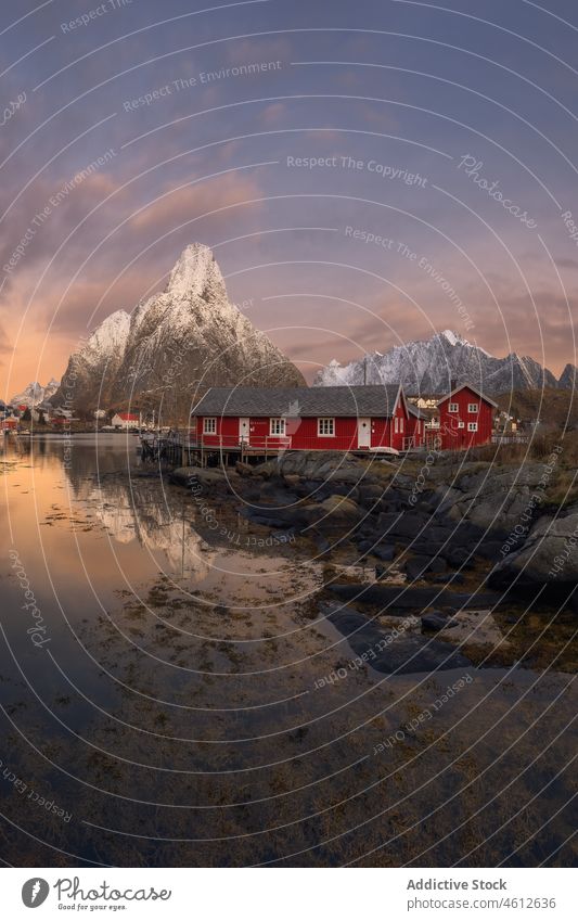 Fischerdorf in der Nähe der schneebedeckten Berge bei Sonnenuntergang Dorf MEER Ufer Berge u. Gebirge Haus Kamm Wolkenloser Himmel Schnee Winter lofoten