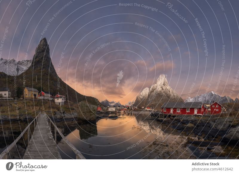 Brücke im Dorf und Berge Berge u. Gebirge Sonnenuntergang Reisender Wasser Ufer wolkig Himmel Landschaft lofoten Norwegen Reine Dämmerung Gipfel Hochland Schnee