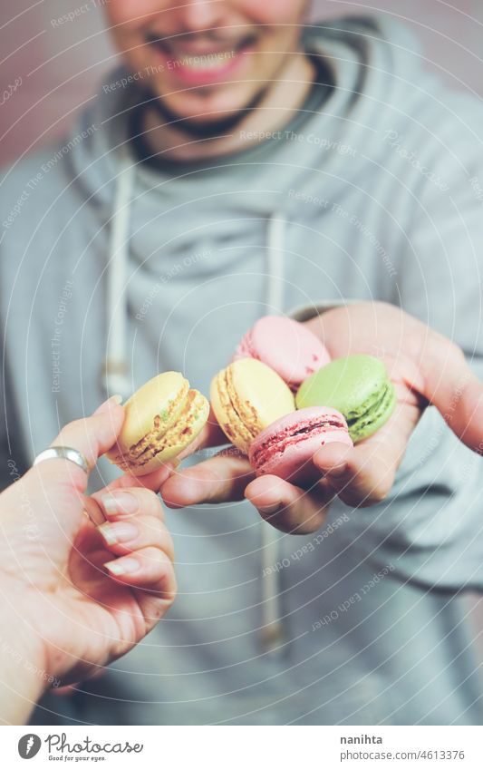 Mann hält Macarons in den Händen Makronen Versuchung Dessert süß Lebensmittel männlich lecker Küche Feinschmecker ungesund Zucker Französisch Varieté mischen