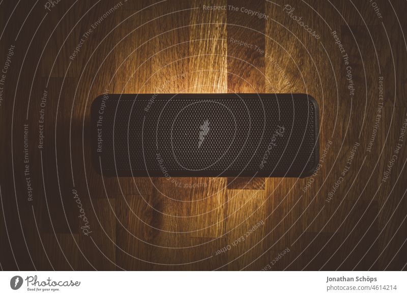 Lautsprecher Musik Box Flatlay auf Holztextur Bassbox Draufsicht Holztisch Lautstärke Licht Minimalismus Musikbox Reduzierung Spot Spotlicht Stillleben dunkel