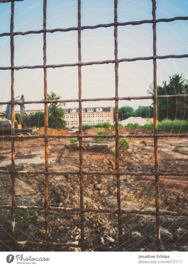 Gitterzaun vor leerem Grundstück mit Baustelle Zaun Absperrung Grundstücksgrenze Grundstück kaufen Grundstückspreise Hausbau Neubau Bagger zu verkaufen mieten