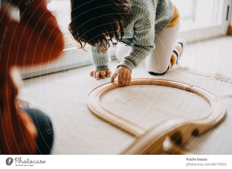 Kind spielt mit Holzeisenbahnspielzeug hölzern Zug Bahngleise Spielzeug Gleise Kindheit authentisch Spielen zu Hause Spaß haben Freizeit & Hobby Farbfoto