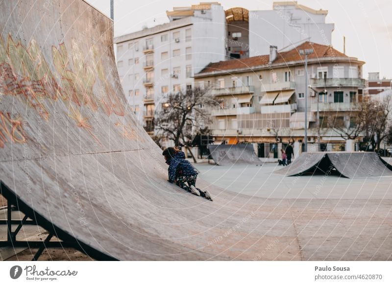 Kind spielt auf Skatepark Kindheit Schlittschuh Skateplatz Halfpipe Holzplatte urban Skateboarderin Außenaufnahme Sport Farbfoto Skateboarding Lifestyle