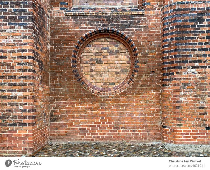 Alte Backsteinfassade einer Kirche mit zugemauertem rundem Fenster Backsteinwand Wand Mauer Fassade alt Backsteine ausgebessert rot Stein Strukturen & Formen