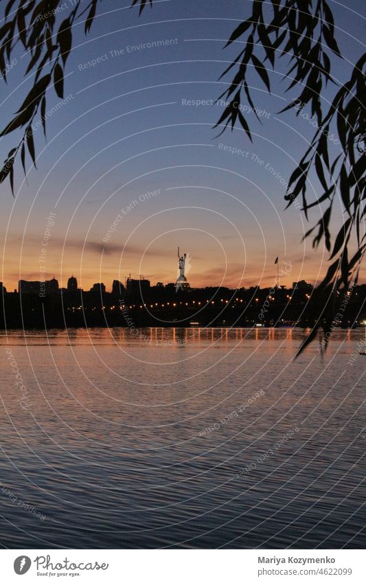 Sonnenuntergang am Ufer des Flusses in Kiew. Strand Bäume Horizont Sommer Großstadt kyiv Ukraine Statue