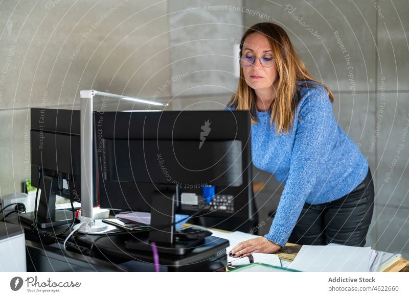 Frau arbeitet am Computer im Büro Browsen Arbeitsplatz modern Business Schriftstück Papierkram Stil Unternehmer Arbeiter Job Dame professionell Arbeitsbereich