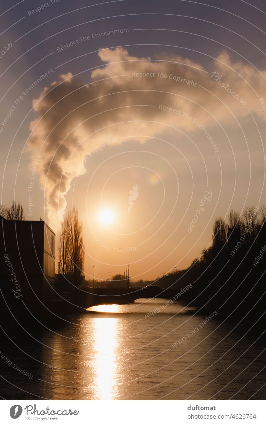 Blockheizkraftwerk bläst Rauch in den Himmel, hinter der Brücke über den Fluss bei Sonnenuntergang Isar Heizkraftwerk München Wasser Bayern Gewässer Niveau