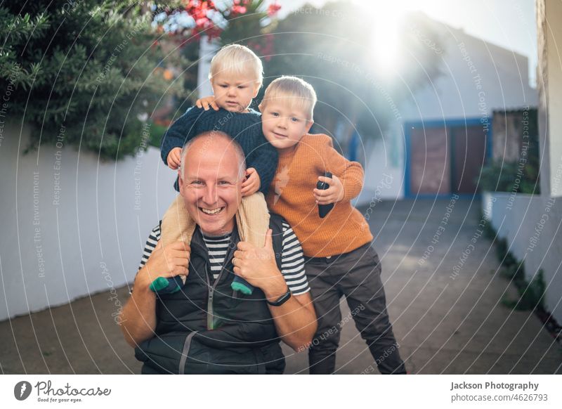 Vater mit seinen beiden Söhnen, die sich im Freien umarmen Sohn Familie Liebe Herbst fallen Kleinkind Baby Brüder Umarmung spielerisch Urlaub Kinder klein