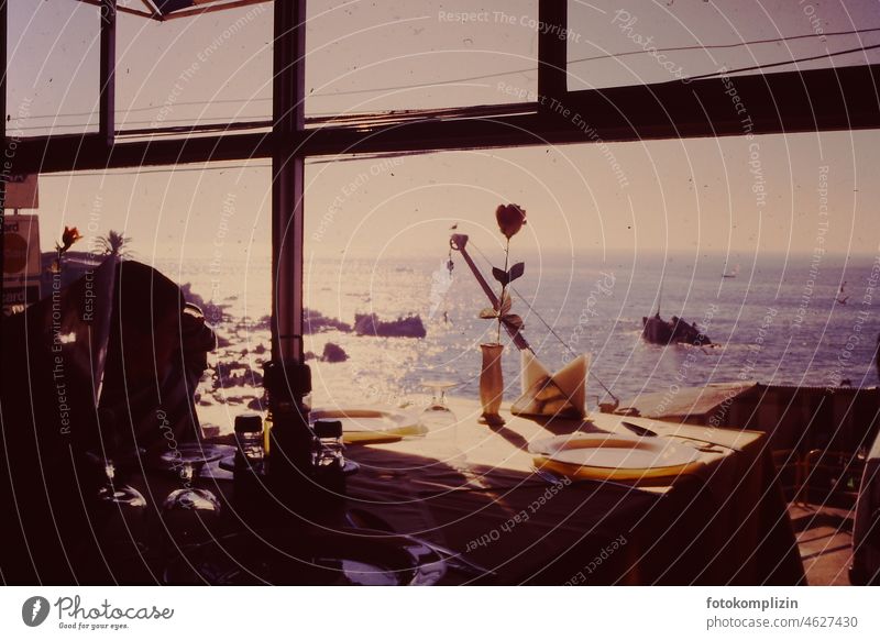 Restaurantfenster mit Blick auf gedeckten Tisch und Meer Küste tisch Aussicht Ausblick nostalgisch Nostalgie retro Fensteraussicht Bar Wasser Himmel Urlaub