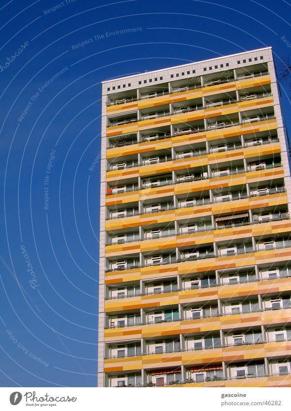 Plattenbau Haus gelb Hochbau blau Balkon mehrfarbig mehrere Gebäude Schnellbau trist Außenaufnahme hoch Blauer Himmel Kontrast Farbe viele Ordnung Architektur