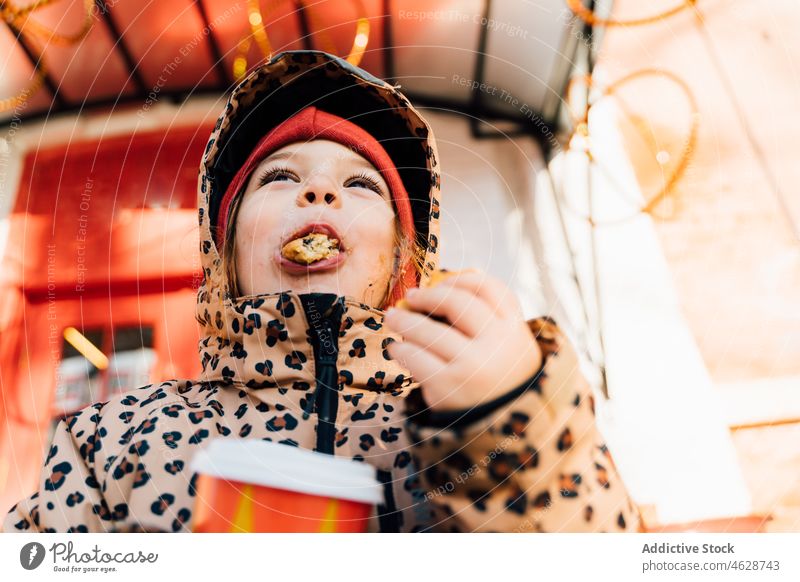 Nettes Mädchen mit Getränk zum Mitnehmen an einem Wintertag Kind Keks Imbissbude Heißgetränk Straße Großstadt kalt Kindheit Dessert trinken Oberbekleidung