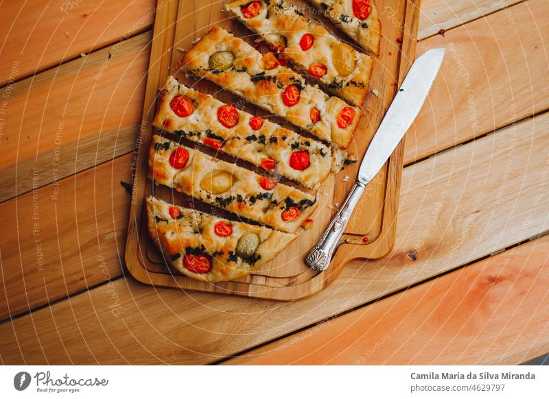 Hausgemachte italienische Focaccia mit Tomaten und Olivenöl auf einem rustikalen Holzuntergrund. Amuse-Gueule Hintergrund backen gebacken Bäckerei