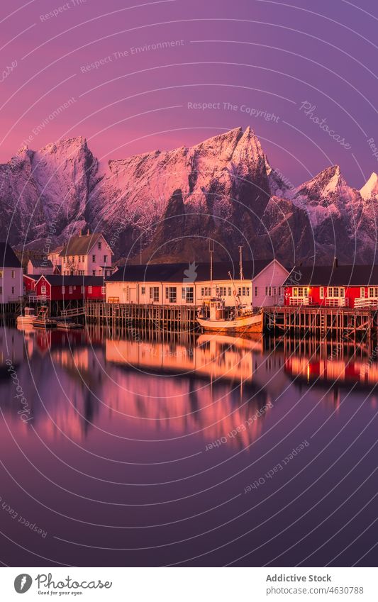 Fischerdorf in der Nähe der schneebedeckten Berge bei Sonnenuntergang Dorf MEER Ufer Berge u. Gebirge Haus Kamm Wolkenloser Himmel Schnee Winter lofoten Reine