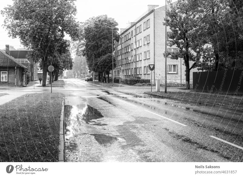 Straße an einem regnerischen Tag in der Stadt. Häuser, Pfützen, Menschen zu Fuß Architektur Herbst schwarz schwarz auf weiß Gebäude Gebäudeaußenseite Großstadt