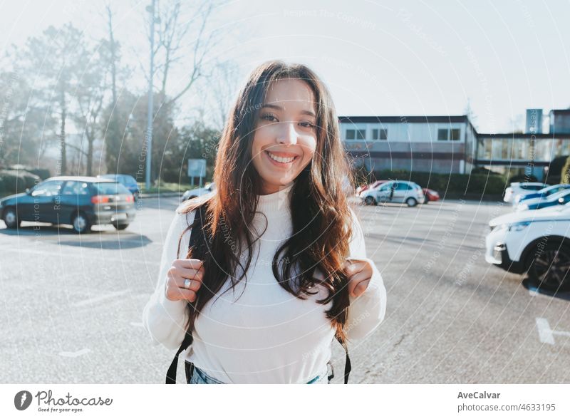 Junger afrikanischer Student, der seinen Rucksack in der Hand hält und sich darauf vorbereitet, wieder in die Klasse auf dem Campus zu gehen. Zurück zur Universität, Studium und Freundschaft an der Schule Konzept. Glücklich beim Studieren